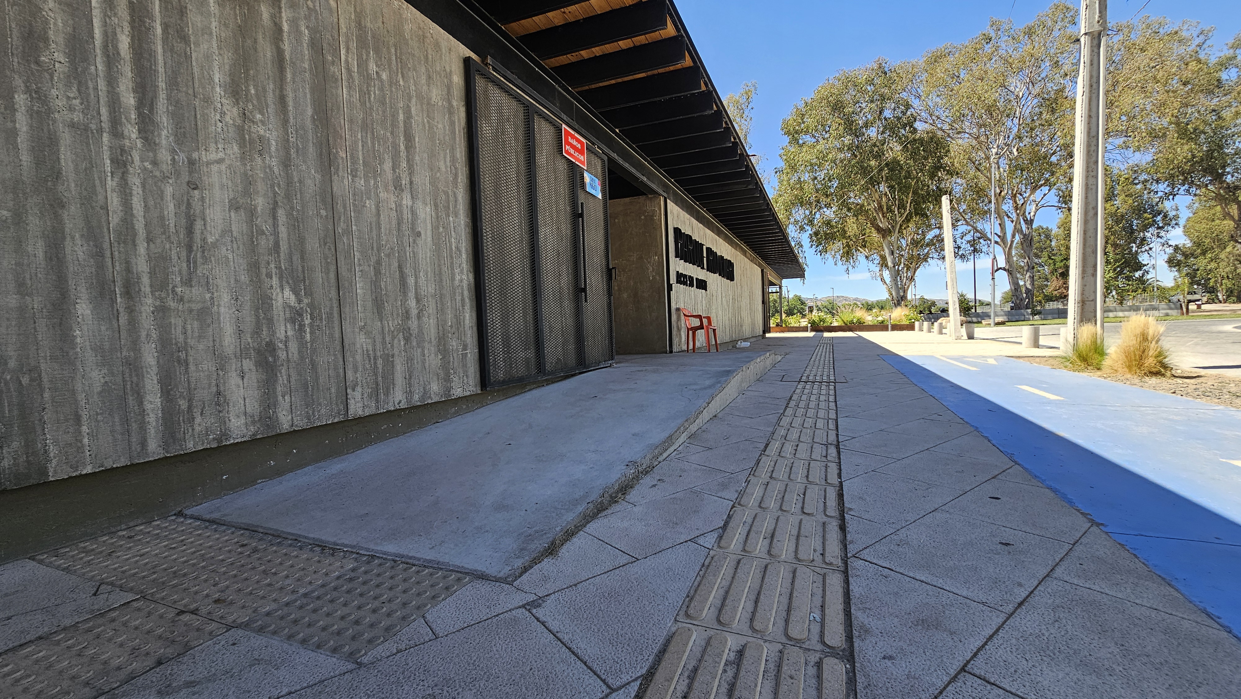 Fotografía de un sector cercano a un edificio del parque, cuenta con rampa y acceso asfaltado